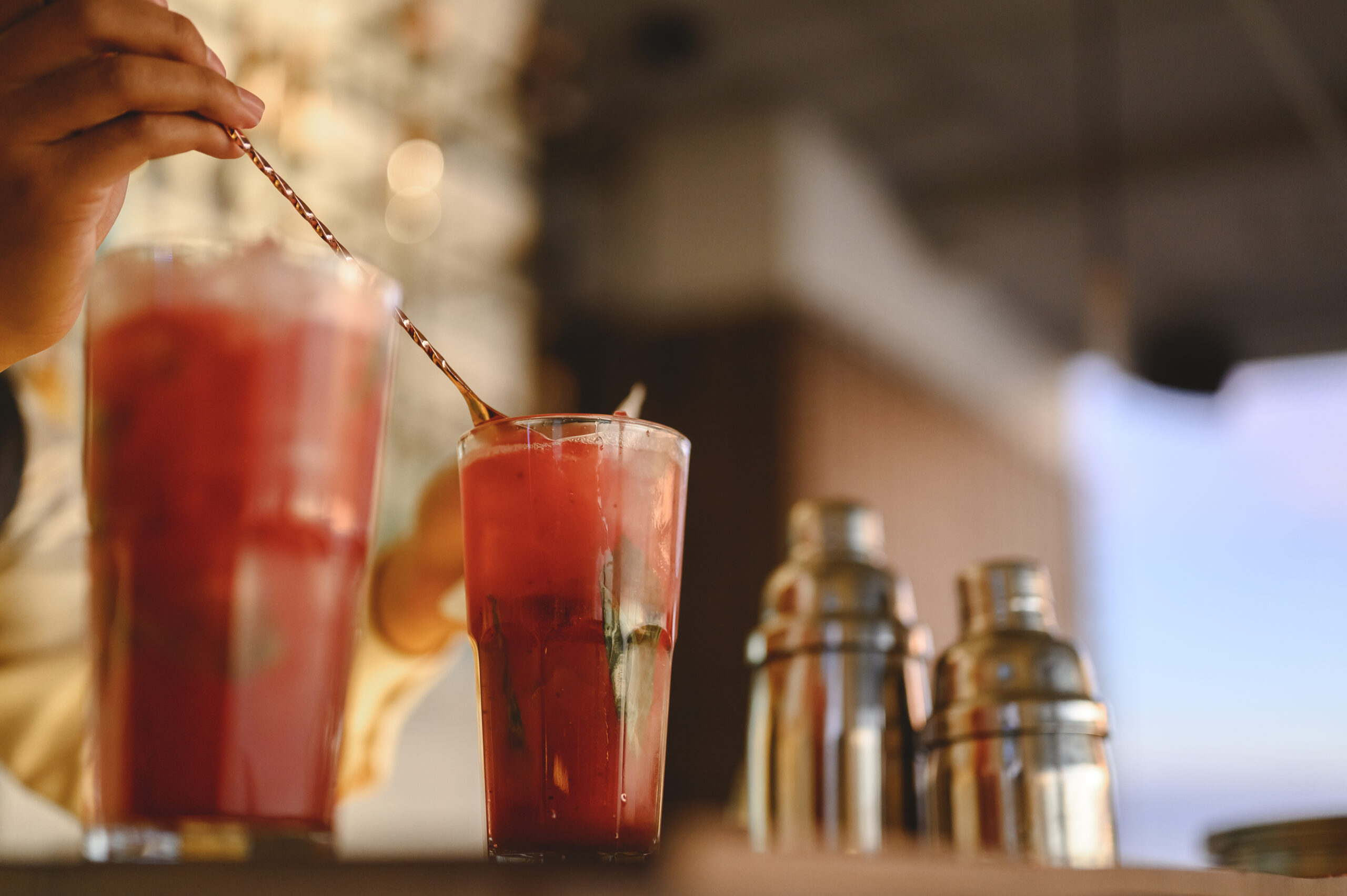 The bartender opens a bottle of red wine using a wine opener. To pour a lot of empty glasses at the bar counter. Blurred background. wine, tasting, open, beverage, bartender, dinner concept.