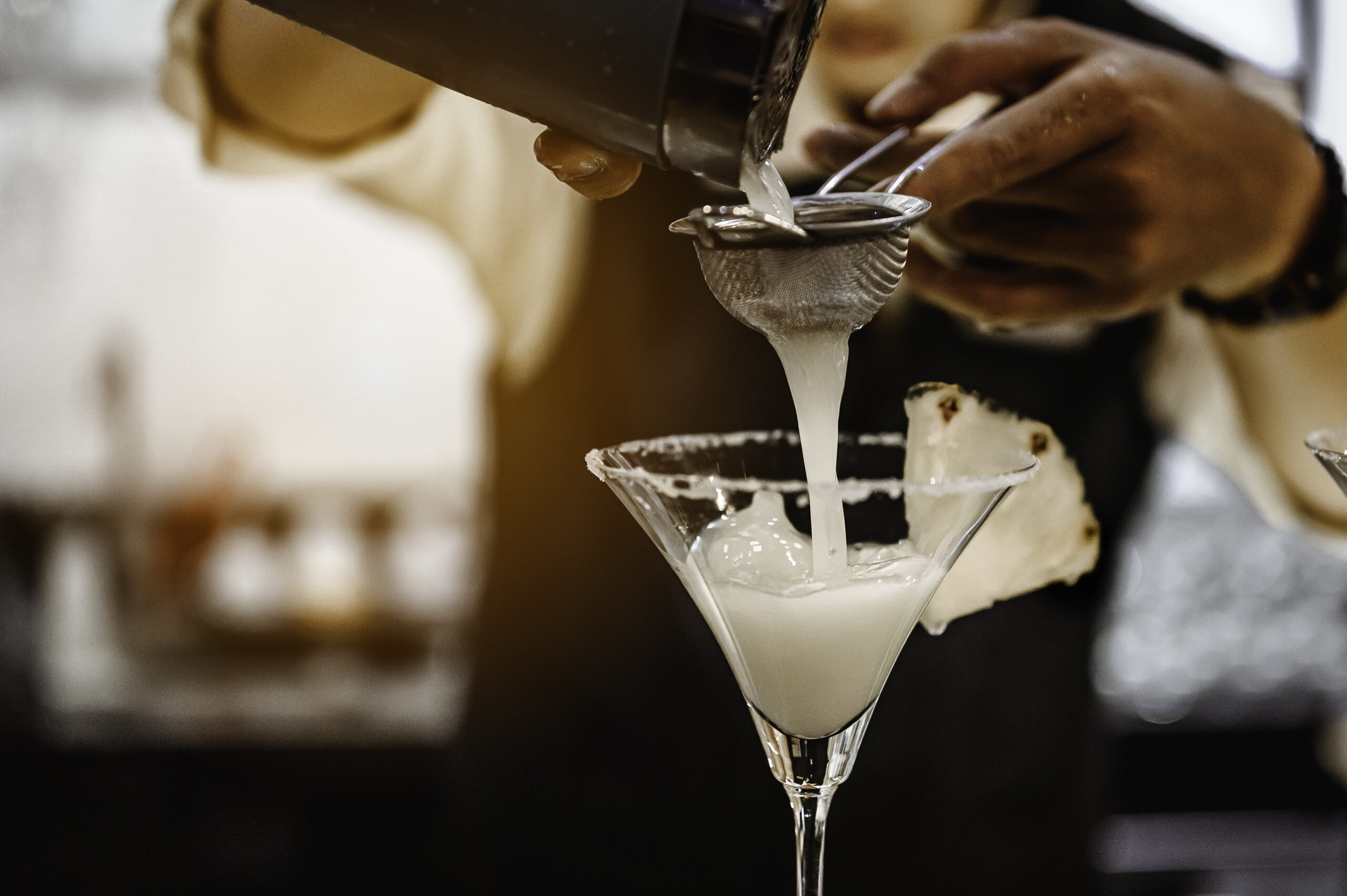 The bartender opens a bottle of red wine using a wine opener. To pour a lot of empty glasses at the bar counter. Blurred background. wine, tasting, open, beverage, bartender, dinner concept.
